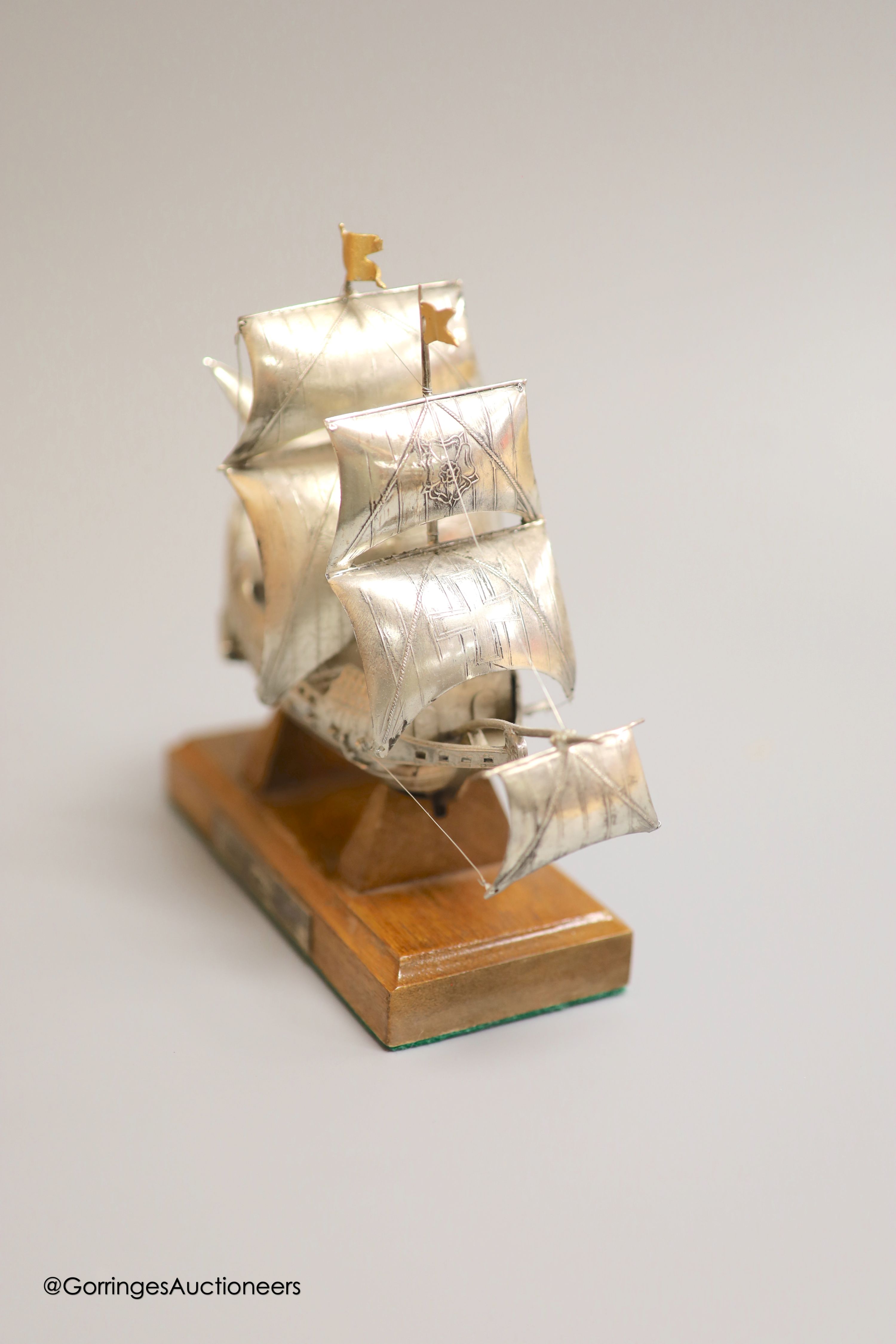 A modern Italian white metal (stamped 925) miniature model of the ship, 'The Golden Hind', (repairs), post 1968 mark, length 16cm, on a wooden stand